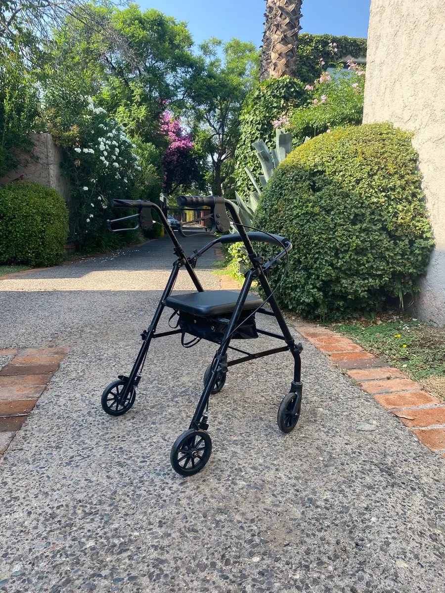 Andador SM Caballero con asiento y frenos en uso al aire libre sobre una vereda